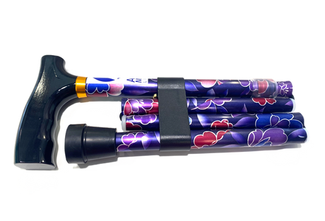 The Allied Medical Floral Foldable Cane features a comfort T-handle, rubber tip, and vibrant floral patterns in purple, pink, and white. It folds easily and is secured with a black strap for convenient carrying.